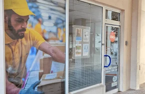 Devanture d'agence de services avec vitrine transparente et porte d'entrée vitrée