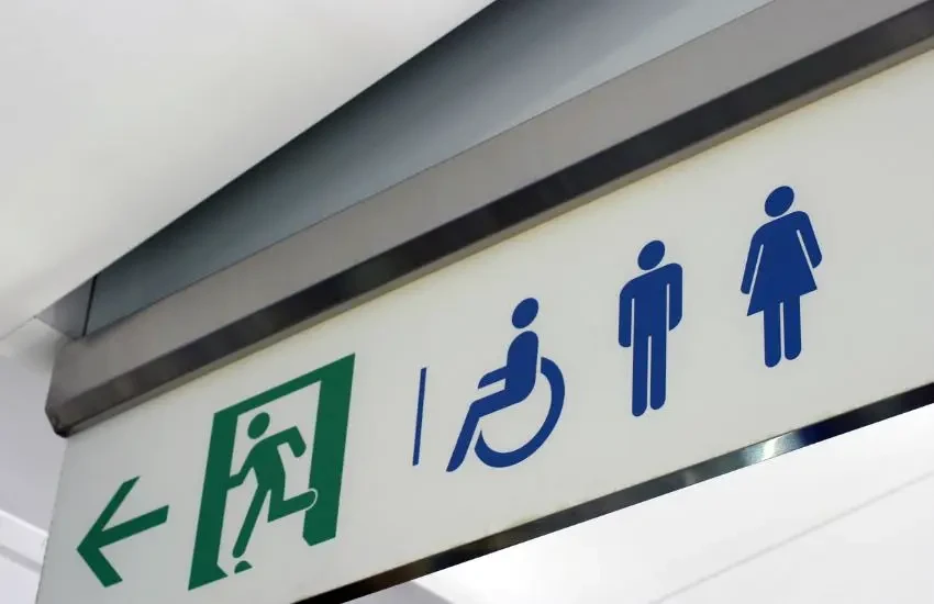 Deux hommes d'affaires en costume franchissent des portes en bois depuis des plateformes rocheuses vers un espace central lumineux